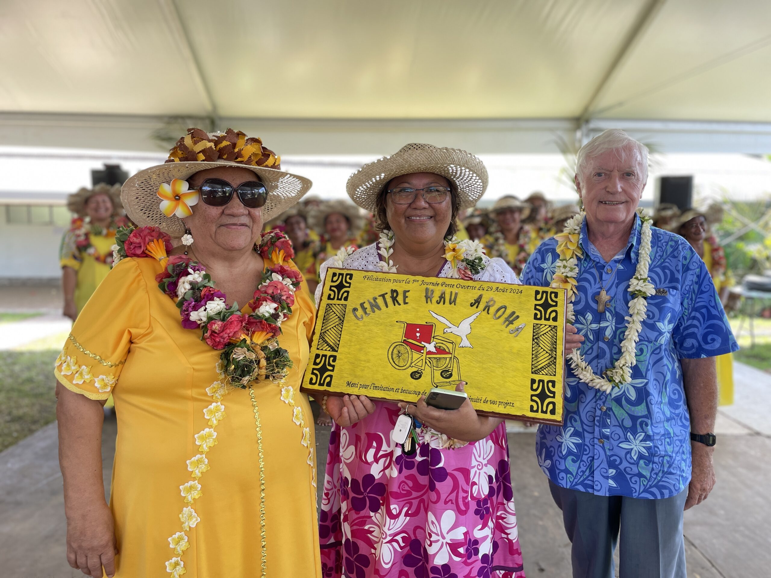 Photo de notre Présidente Mme Henriette KAMIA offrant un magnifique panneau en bois confectionné par notre association Huma Mero, en cadeau pour HAU AROHA.